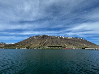 Isafjordur, Iceland - panorama view of the small town on Pollur fjord with partial snow covered mountains in the background 