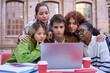© CarlosBarquero - Front view of group of students working together using and looking concentrated at laptop outdoor. Studying for exams and sharing knowledge sitting at table on university campus. Education technology
