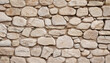 © Uuganbayar - Natural old beige stone wall textured background. Close up. Copy space.
