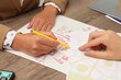 © New Africa - Real estate agent working with client at wooden table, closeup
