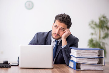 Wall Mural - Young male employee working in the office