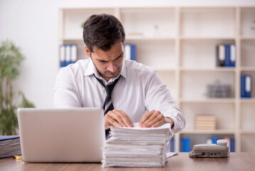 Wall Mural - Young male employee working in the office