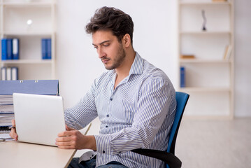 Wall Mural - Young male employee working in the office