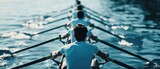 A team of rowers moves in sync through calm waters, showcasing strength and unity.