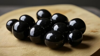 Wall Mural -  Shiny black olives on a wooden surface