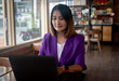 © Kanokwan - Businesswoman sitting in the cafe using laptop working account report finance, coffee break time freelance lifestyle  concept