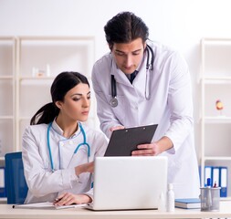 Wall Mural - Two young doctors working in the clinic