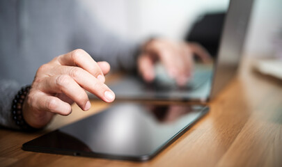 Wall Mural - Closeup man hand working on digital tablet, sitting at home office.