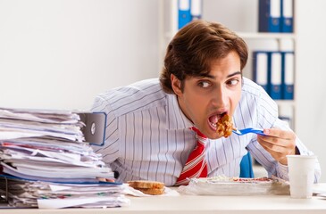 Wall Mural - Man having meal at work during break