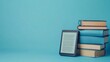 © Elmira - A contemporary ebook reader is positioned next to a carefully arranged collection of hardcover books against a serene light blue backdrop, showcasing both traditional and digital reading