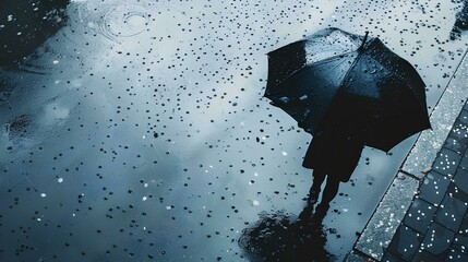 Wall Mural - shadow in water, reflecting an umbrella and raindrops. The person is seen from above with their head raised as if they were looking at something or someone far away