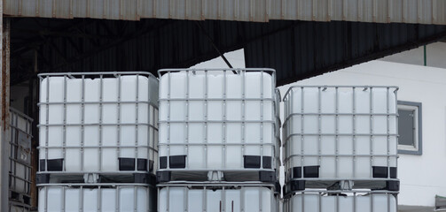 Wall Mural - A stack of white plastic containers are piled on top of each other. Stacked IBC Containers.