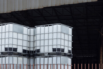 Wall Mural - A stack of white plastic containers are piled on top of each other. Stacked IBC Containers.