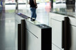© Rattanachat - A man walks past a pair of electronic turnstiles. smart turnstiles.