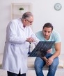 © Elnur - Young back injured man visiting experienced male doctor