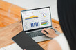 © kenchiro168 - Businesswoman interacts with a digital sales dashboard displaying various performance metrics and analytics.