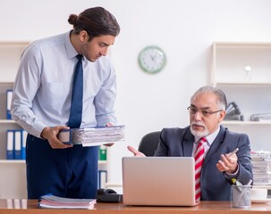 Wall Mural - Old boss and young male employee in the office