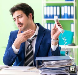 Poster - Businessman unhappy with excessive work sitting in the office