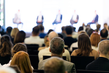 Wall Mural - rear view of the audience at a business conference meeting event listening to the speakers speech