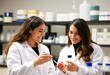 © Duman - Two female scientists in lab coats smiling as they examine resul