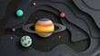© Odisdca - Un fondo gris oscuro con los planetas de nuestro sistema solar representados en un estilo de recorte de papel. El planeta Saturno está centrado y tiene sus anillos completamente visibles.