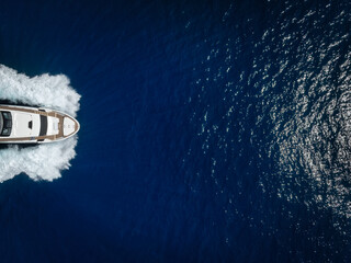 Wall Mural - aerial overhead close up view of a bow of a luxury yacht sailing with high speed over the ocean with