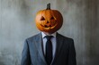 © Minerva Studio - Businessman wearing suit posing with a jack-o'-lantern on his head