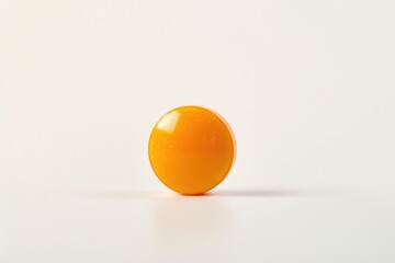 Poster - A single orange egg sitting on a white surface