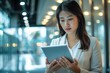 © Fotograf - A woman looks at her tablet, possibly checking emails or browsing the internet