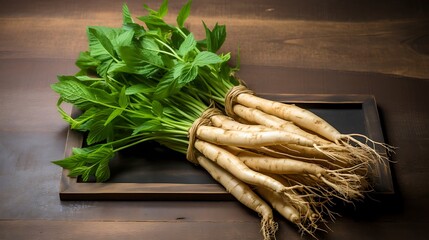 Wall Mural - A bunch of fresh white roots with green leaves tied together with twine on a wooden table.