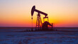 © NaphakStudio - image captures silhouette of an oil pump jack against stunning sunset, showcasing industrial landscape in serene environment.