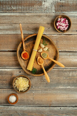 Fresh ingredients and spices laid out on a rustic wooden table ready for pasta preparation