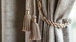 © Suphawan - A close-up of a curtain with decorative tassels and a textured fabric, adding a luxurious touch to the interior design.
