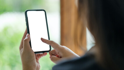 Wall Mural - close up shot of hands holding a smartphone with a blank screen, for mockup designs or app interface