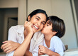 © SensSai/peopleimages.com - Happy mother, child and kiss with love on bed for bonding, moment or holiday together at home. Mom, little boy and kid with smile for embrace, weekend or motherhood affection on cheek in bedroom