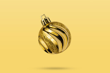 Wall Mural - Golden Christmas ball isolated on yellow background