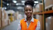 © Johannes - African Woman in orange vest in logistics center, horizontal banner. Smiling portrait, copy space, job offer.