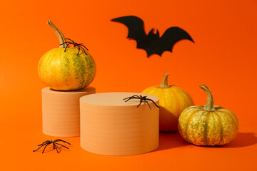 Poster - Halloween celebration. Pumpkins, black paper bat, spiders and podiums on orange background