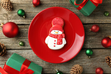 Sticker - Delicious cookie in shape of snowman and Christmas decor on wooden table, flat lay