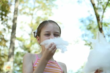 Sticker - Portrait of little girl eating sweet cotton candy in park