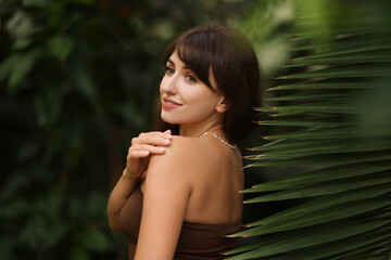 Poster - Portrait of smiling woman near palm leaves outdoors