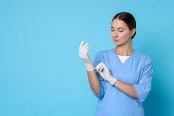 Wall Mural - Nurse in medical uniform wearing gloves on light blue background, space for text