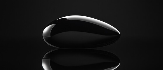 Wall Mural - A black object with a shiny surface is shown in a black background