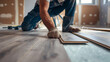 © retrostudio - Professional handyman installing laminate flooring in a new apartment