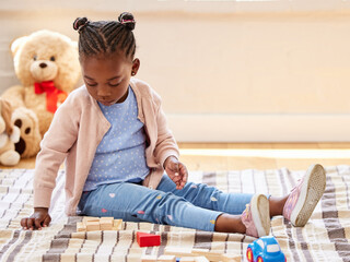 Canvas Print - Toddler, playing and building blocks in game for growth, development and learning for motor skills. African child, toys and puzzle in education, creativity or fun for cognitive ability in family home