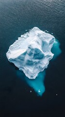 Wall Mural - an aerial view of an iceberg floating in the water, showcasing its massive size and intricate detail