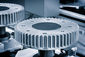 Poster - Two gears are shown in close up, one of which is missing a tooth. Concept of precision and engineering, as the gears are likely being manufactured or assembled for a machine or device