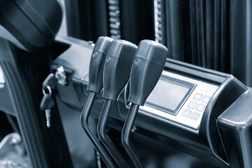 Poster - A forklift has a keypad and three levers. The levers are black and the keypad is silver