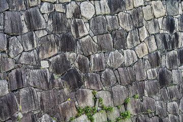 Traditional japanese stone wall moat at the base of Osaka Castle. Texture background.