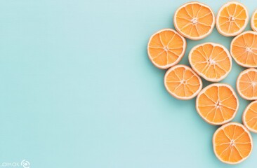 Heart-shaped arrangement of vibrant orange citrus slices on a light blue background